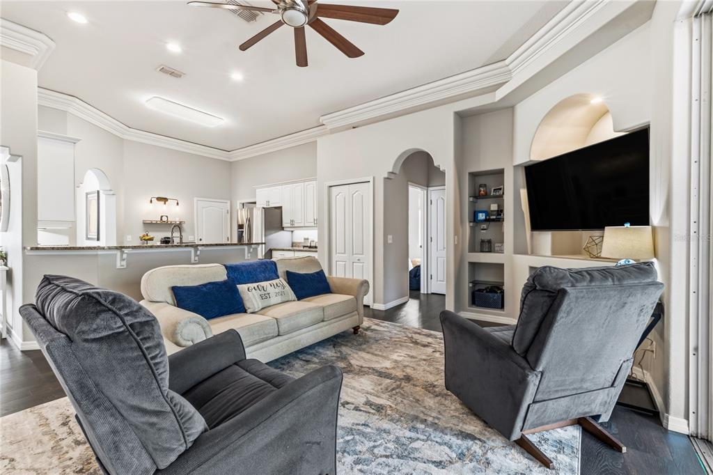 A living room with two gray armchairs, a beige sofa, and a built-in television niche — 1015 ROBIN LANE, WINTER HAVEN, FL