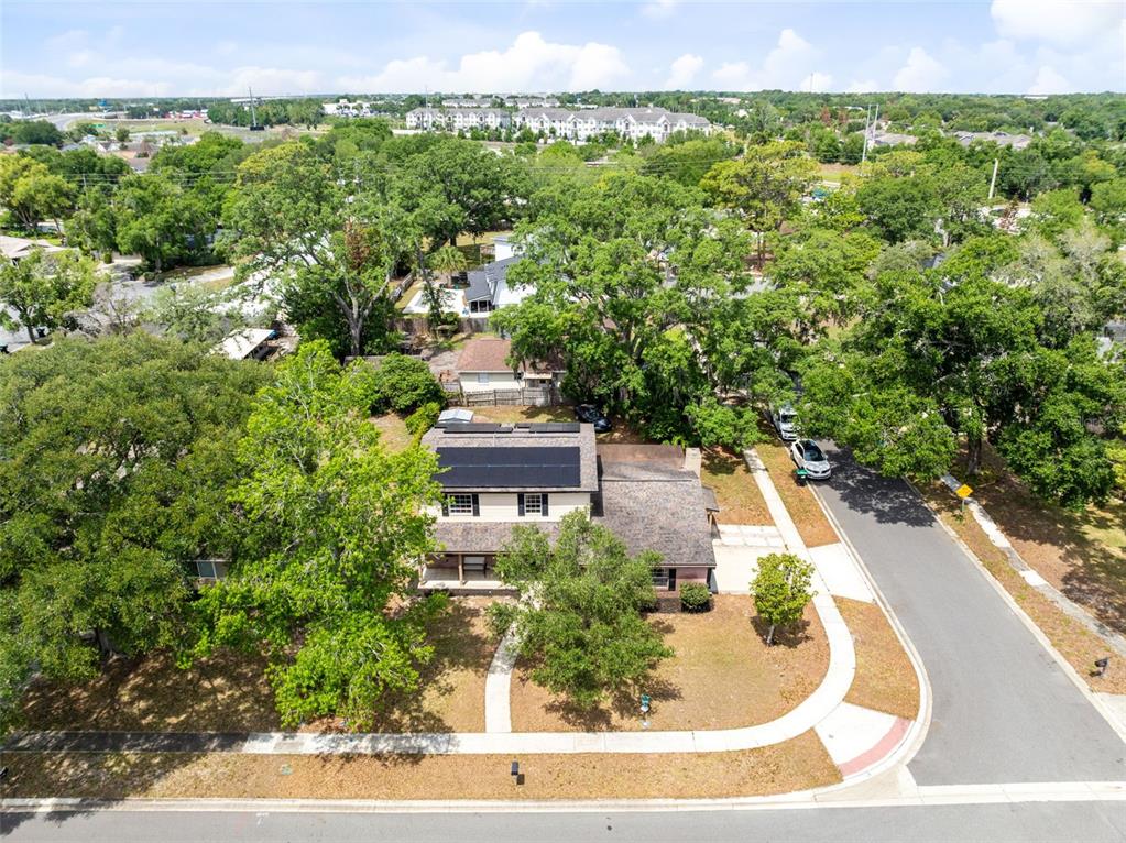 An aerial view shows a two-story house with solar panels on a corner lot — 8698 HILLSIDE DRIVE, ORLANDO, FL