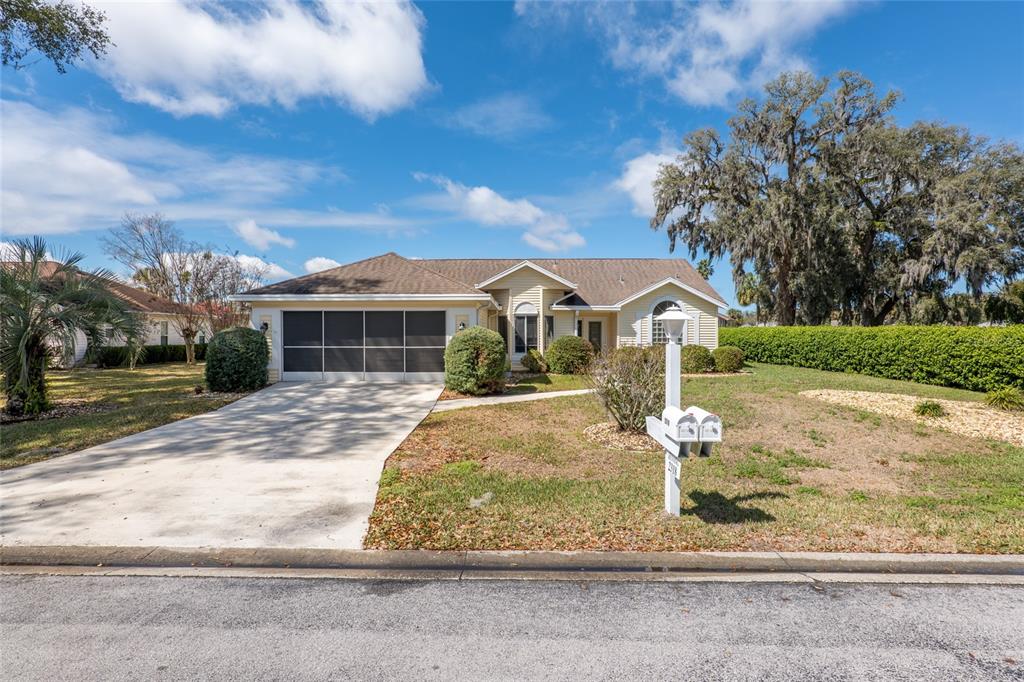 A single-story house with a screened garage, light siding, and a front lawn — 2318 NW 50TH AVENUE, OCALA, FL