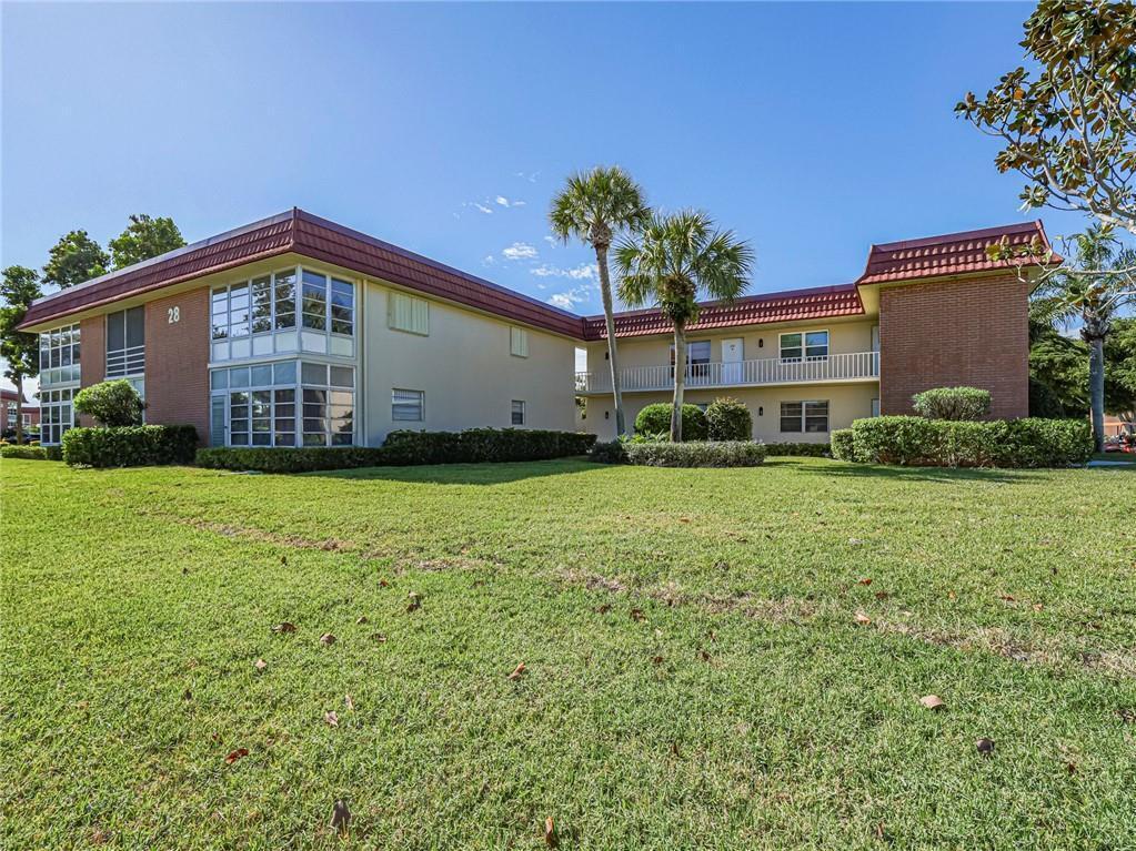 A two-story apartment building with a red tile roof and a large grassy lawn — 28 Pine Arbor Lane # 101, Vero Beach FL 32962, VERO BEACH, FL