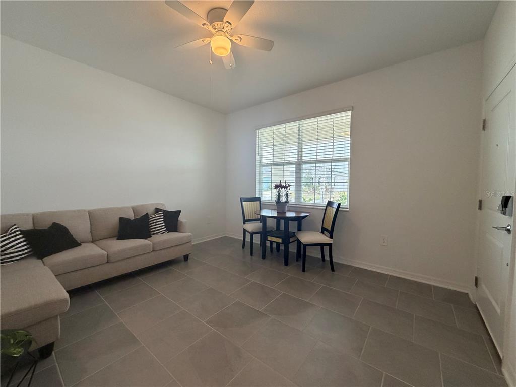 A living room features a beige sectional sofa, a small dining set, and tile flooring — 652 GROVE STREET, WINTER HAVEN, FL