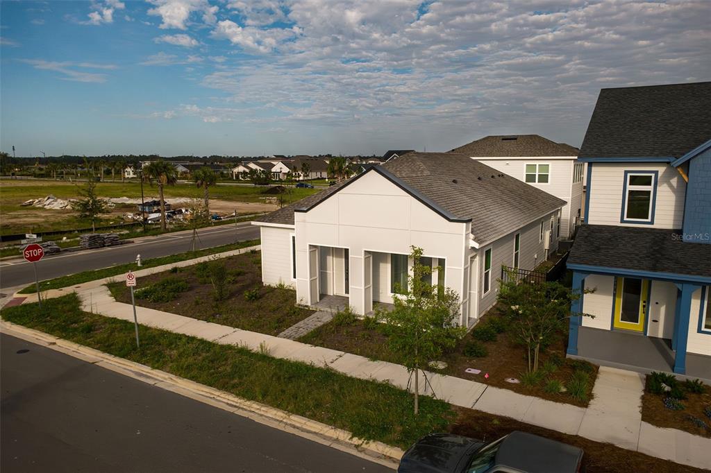 An aerial view shows a modern white single-story house next to a blue-trimmed home — 2952 EMBARK TRAIL, ST CLOUD, FL