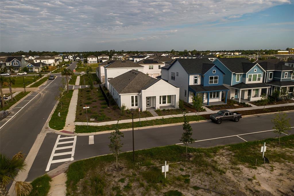 An aerial view shows a modern white house and a blue house in a suburban neighborhood — 2952 EMBARK TRAIL, ST CLOUD, FL