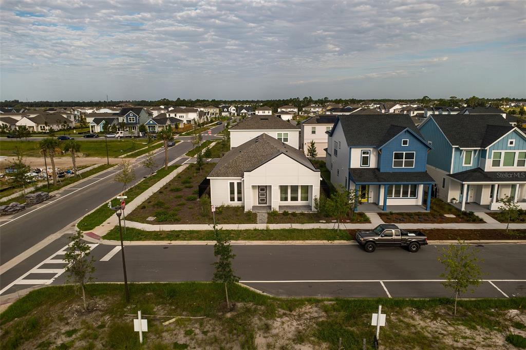 An aerial view shows a modern white house next to a blue house on a street — 2952 EMBARK TRAIL, ST CLOUD, FL