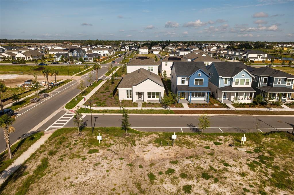 An aerial view shows a vacant lot in the foreground facing a row of houses — 2952 EMBARK TRAIL, ST CLOUD, FL