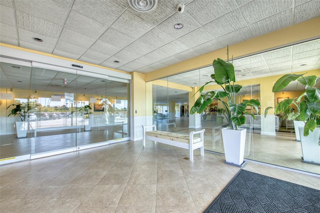 A swimming pool sits in front of a multi-story apartment building near a waterfront — 31 ISLAND WAY UNIT 508, CLEARWATER BEACH, FL
