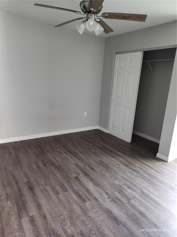A bedroom with gray walls, wood-look flooring, a ceiling fan, and an open closet — 5580 NE 35TH STREET, SILVER SPRINGS, FL