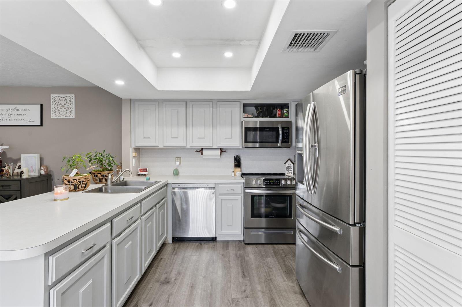 A kitchen with gray cabinets, stainless steel appliances, and a white countertop island — 1425 Oxford Lane, Boynton Beach FL 33426, BOYNTON BEACH, FL