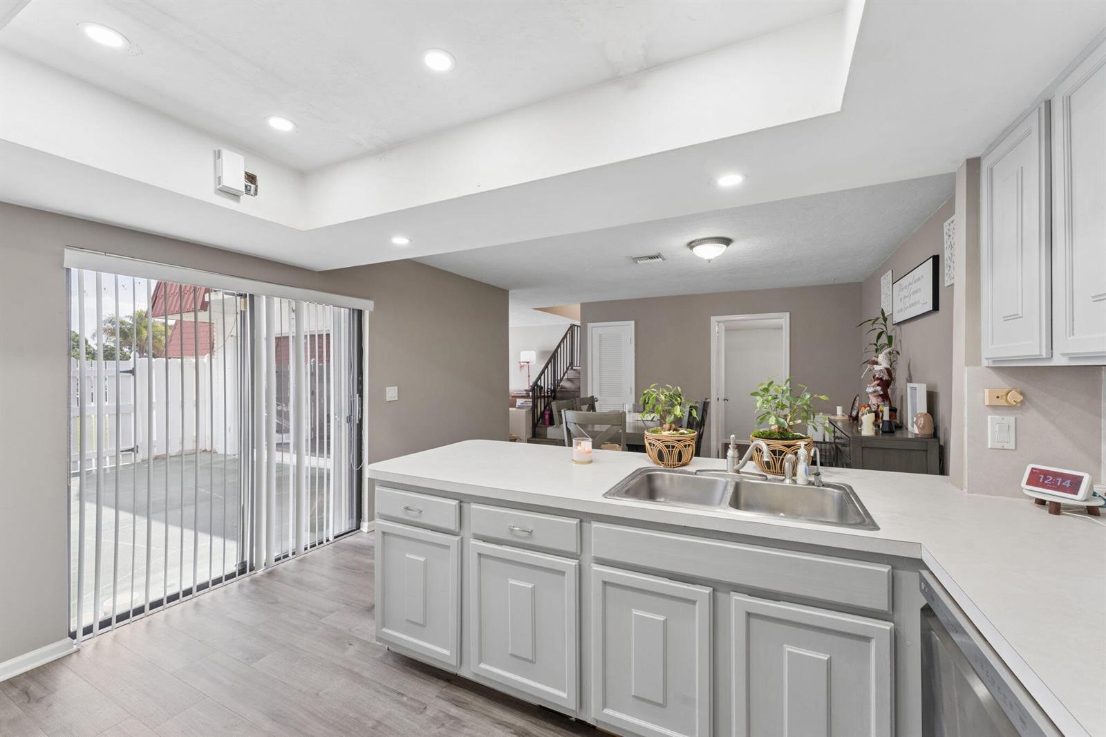A bedroom features a wooden bed frame, matching dresser, light wood-look flooring, and white closet doors — 1425 Oxford Lane, Boynton Beach FL 33426, BOYNTON BEACH, FL