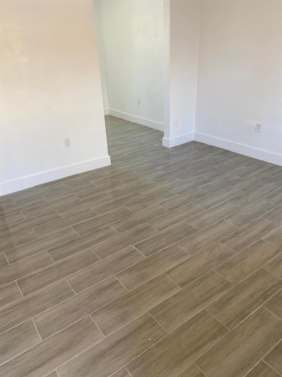 A room with light-colored walls, white baseboards, and wood-look tile flooring — 460 SW 7th Street, Miami FL 33130, MIAMI, FL