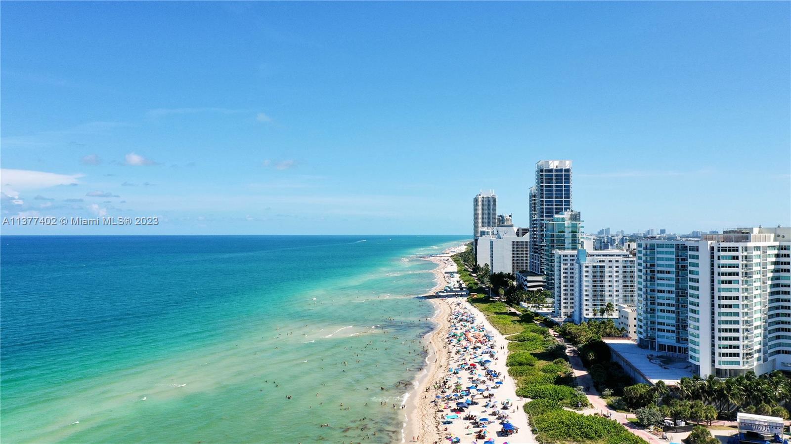 An aerial view of a sandy beach lined with high-rise buildings along the ocean — 7300 Ocean Ter # 110, Miami Beach FL 33141, MIAMI BEACH, FL