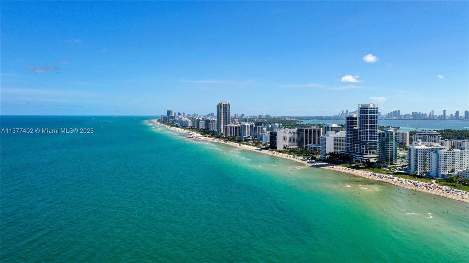 An aerial view of a sandy beach coastline lined with high-rise buildings and turquoise water — 7300 Ocean Ter # 110, Miami Beach FL 33141, MIAMI BEACH, FL