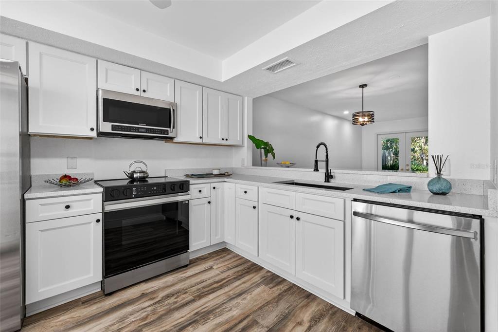 A white multi-unit residential building features attached garages, green awnings, and a paved driveway — 5300 BAYSHORE BOULEVARD UNIT C6, TAMPA, FL