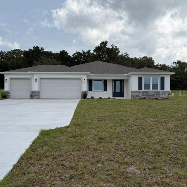 A single-story house with a three-car garage, stone accents, and a concrete driveway — 380 E DUSTY COURT, HERNANDO, FL