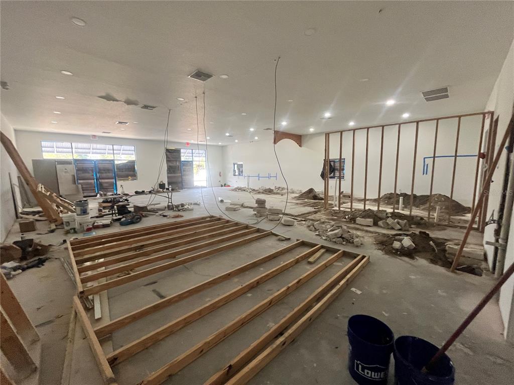 An interior view of a commercial space under construction with exposed framing and debris — 1989 21ST STREET NW, WINTER HAVEN, FL