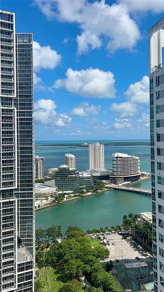 A high-angle view shows a bay and city skyline framed by two tall residential towers — 77 SE 5TH ST. # 3614, Miami FL 33131, MIAMI, FL