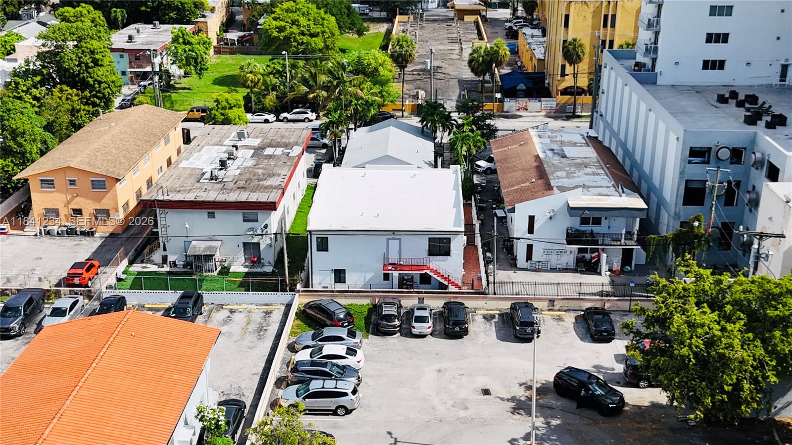 An aerial view shows several buildings and a parking lot with multiple parked cars — 1238 SW 4th St, Miami FL 33135, MIAMI, FL