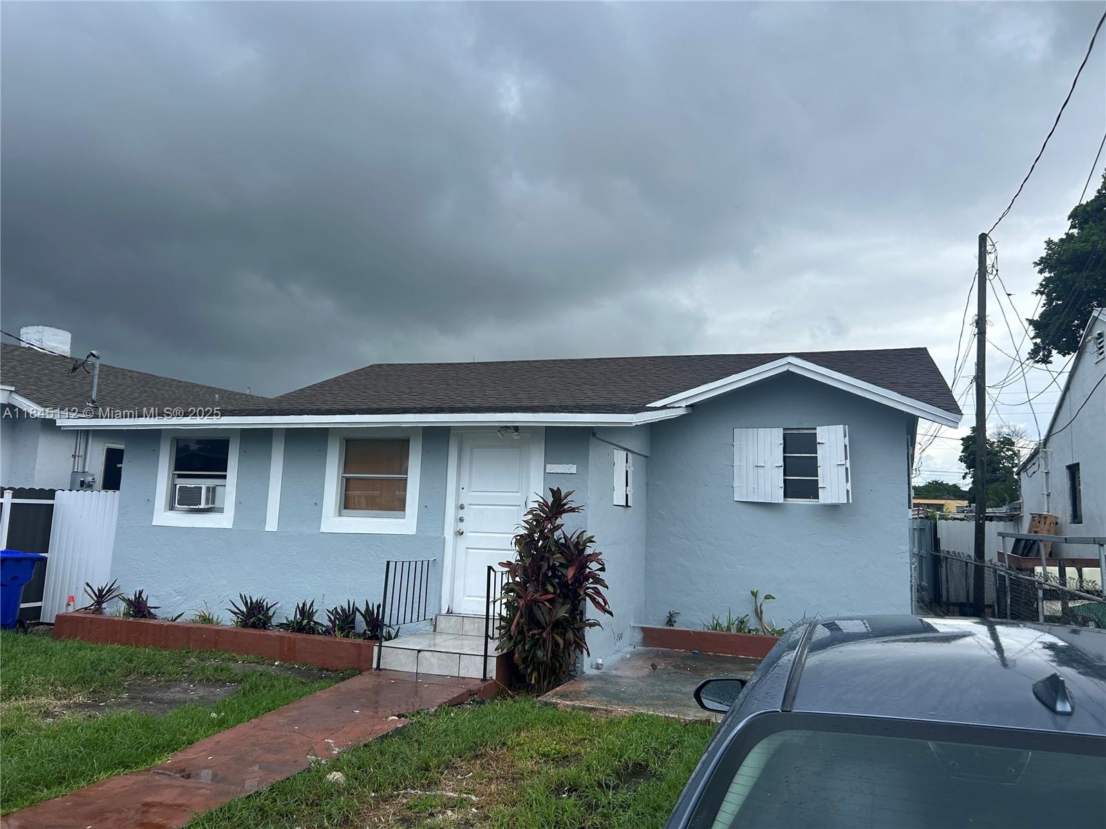 A single-story light blue house with a brown roof and a white front door — 2708 NW 22nd Ct, Miami FL 33142, MIAMI, FL