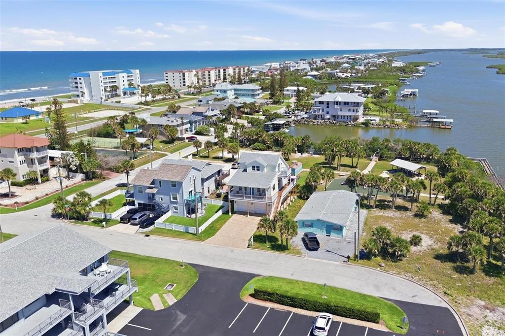 An aerial view shows coastal houses situated between the ocean and a bay — 856 LADYFISH AVENUE, NEW SMYRNA BEACH, FL