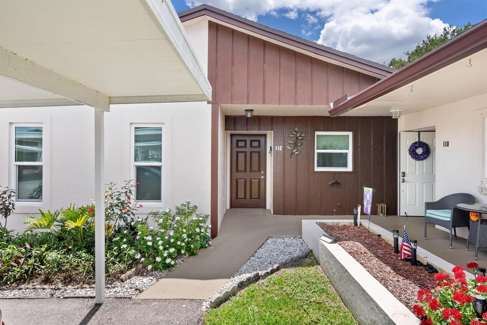The exterior of a residential building features a brown front door, siding, and a carport — 6531 SE Federal Highway # M112, Stuart FL 34997, STUART, FL