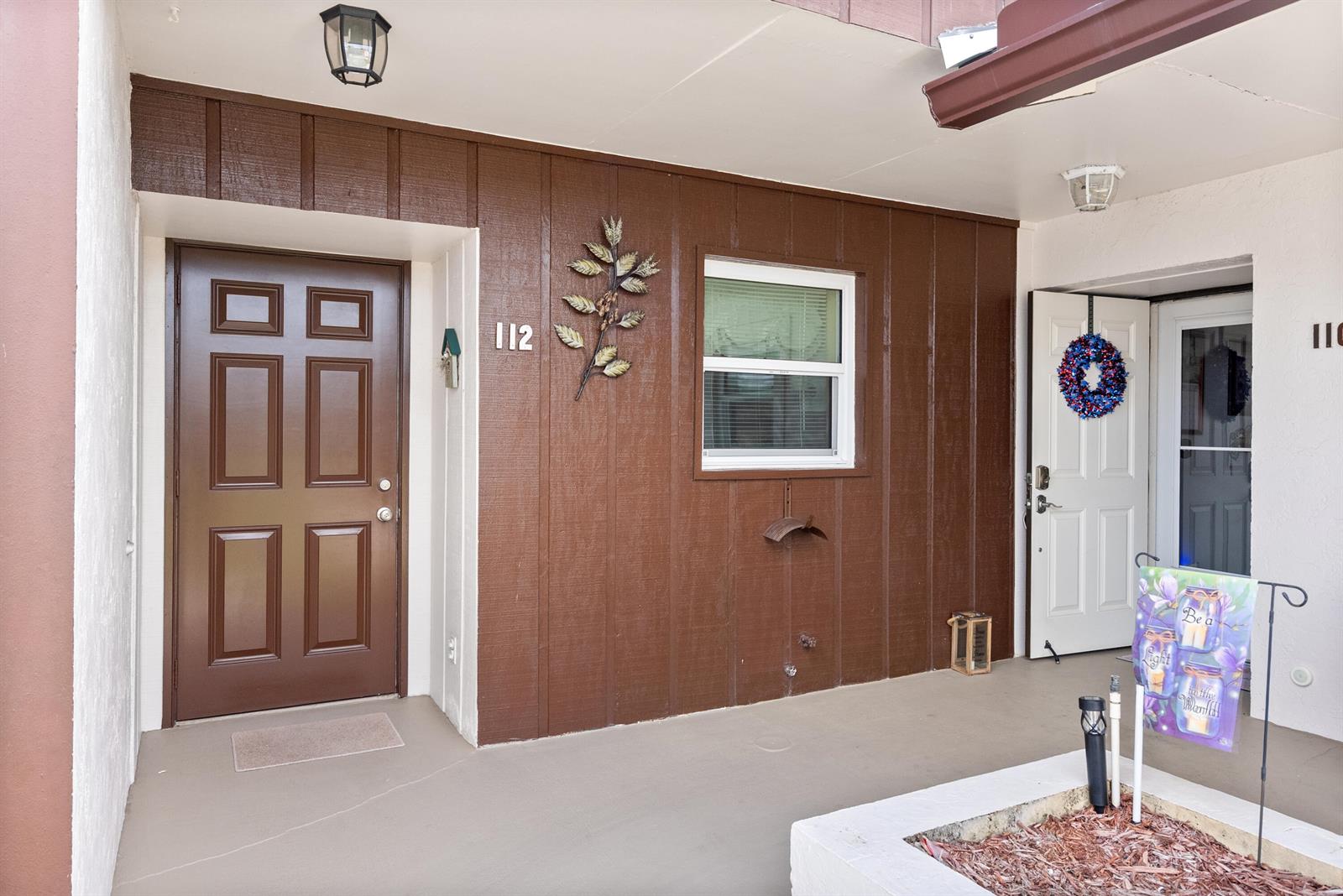 A brown door and a window are on the exterior wall of this apartment entrance — 6531 SE Federal Highway # M112, Stuart FL 34997, STUART, FL