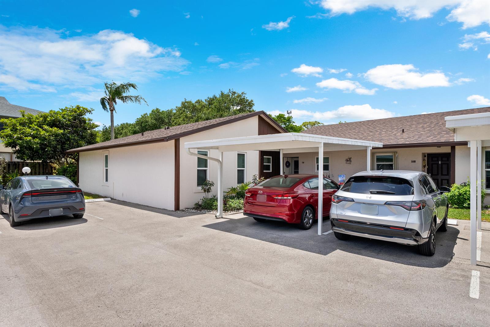 A single-story building with a carport, paved parking, and three parked cars — 6531 SE Federal Highway # M112, Stuart FL 34997, STUART, FL