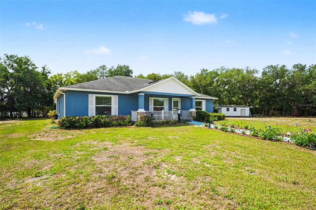 A blue single-story house with a front porch sits on a grassy lot with trees — 3147 SYDNEY DOVER ROAD, DOVER, FL