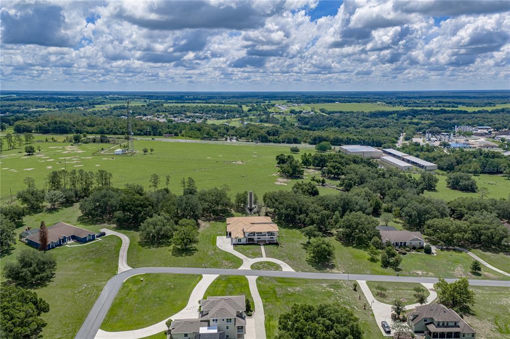 An aerial view shows a large house with a multi-level deck on a rural lot — 37624 SKY RIDGE CIRCLE, DADE CITY, FL