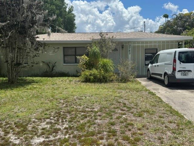 A single-story house with light-colored siding and a white van parked in the driveway — 3763 KOSTEN PLACE, SARASOTA, FL