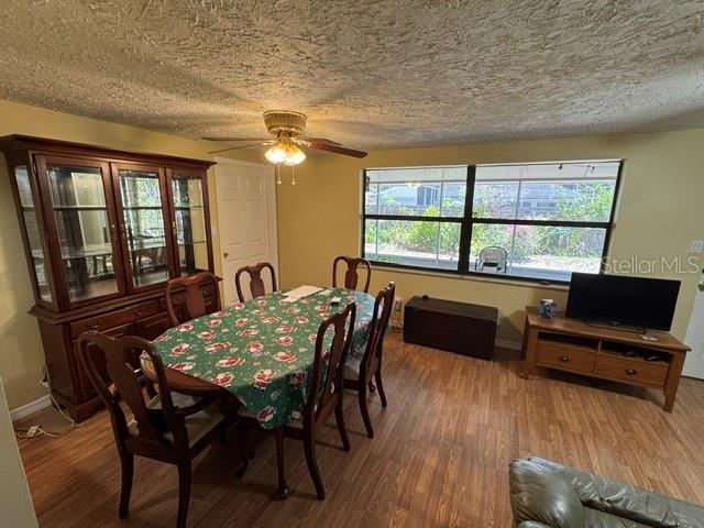 A dining room with a wooden hutch, a table with a holiday tablecloth, and a television — 3763 KOSTEN PLACE, SARASOTA, FL