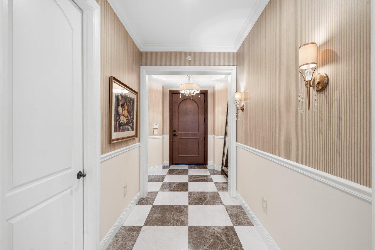 A hallway features a checkered marble floor, striped wallpaper, and a dark wood front door — 3000 S Highway A1a # 302, Jupiter FL 33477, JUPITER, FL