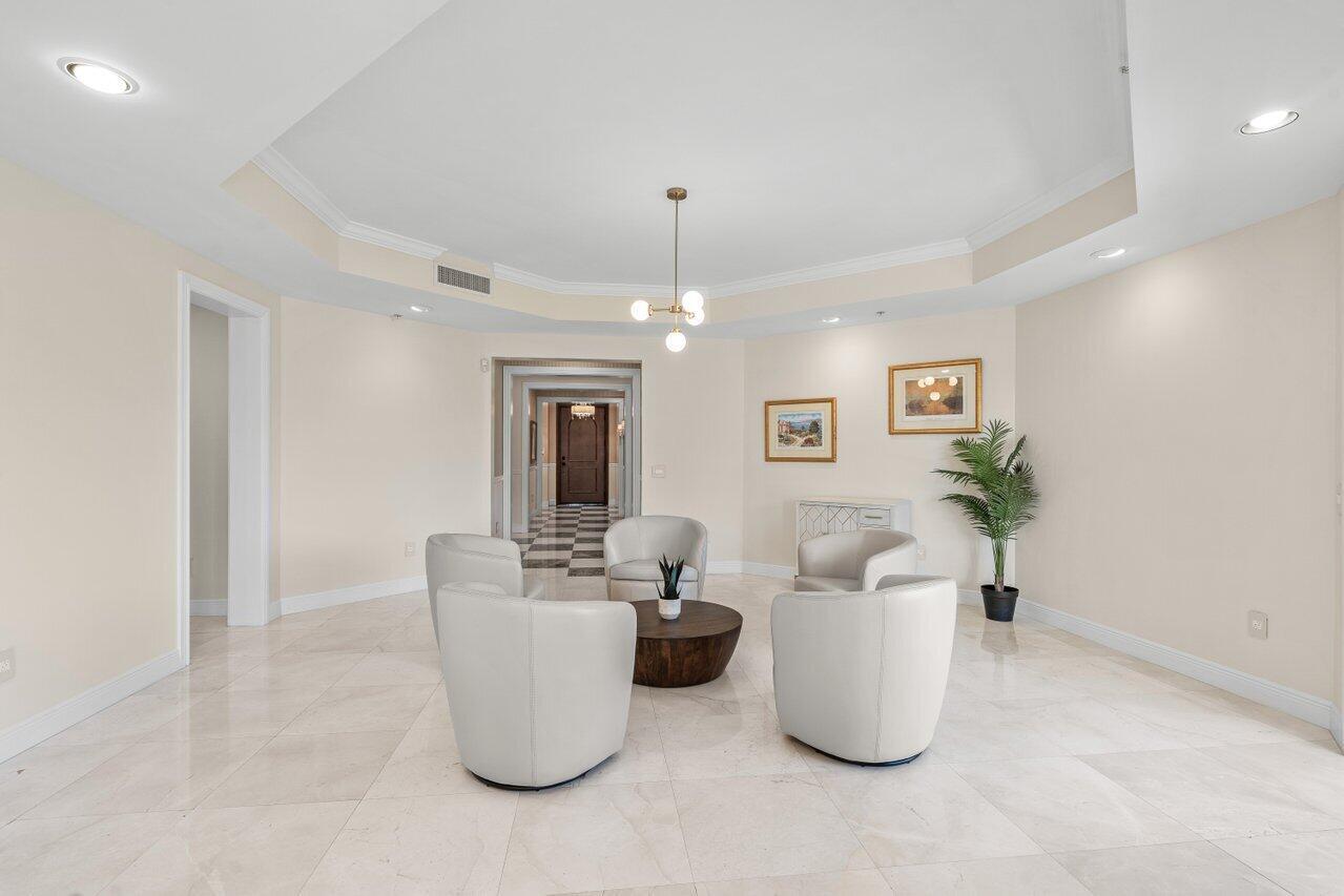 A spacious, light-colored room features a tray ceiling, tile flooring, and three modern armchairs — 3000 S Highway A1a # 302, Jupiter FL 33477, JUPITER, FL