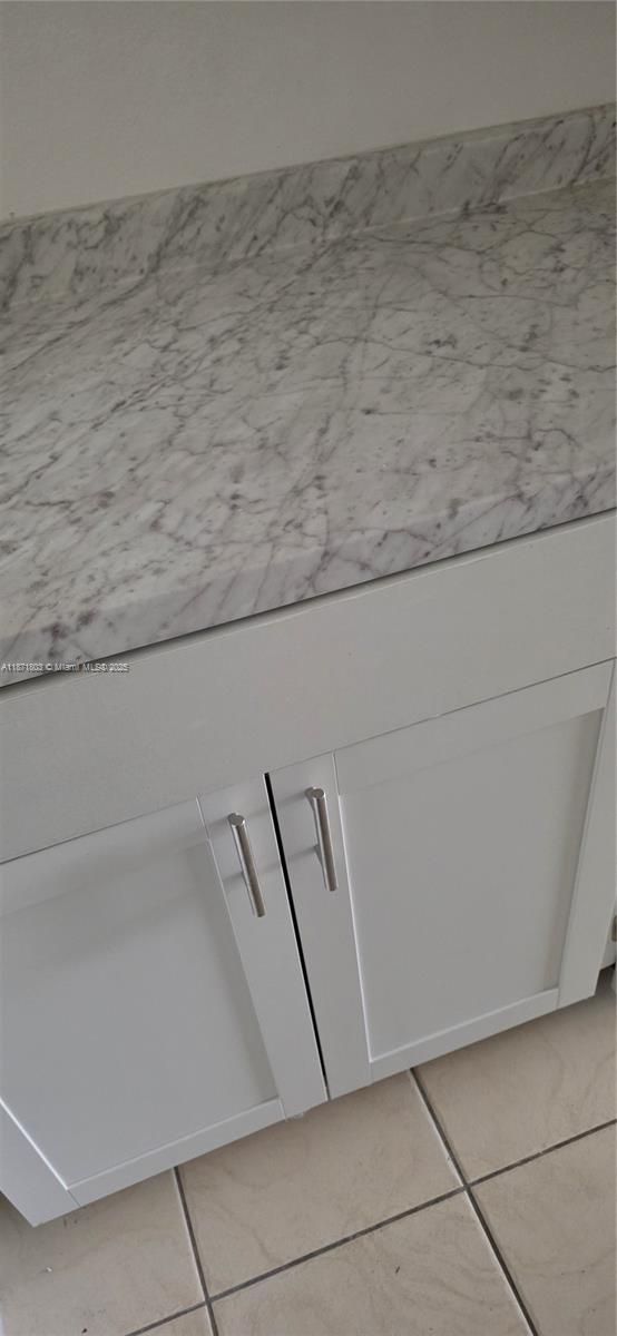 A white cabinet with silver handles sits beneath a marble countertop with a backsplash — 17901 NW 68th Ave # T203, Hialeah FL 33015, HIALEAH, FL