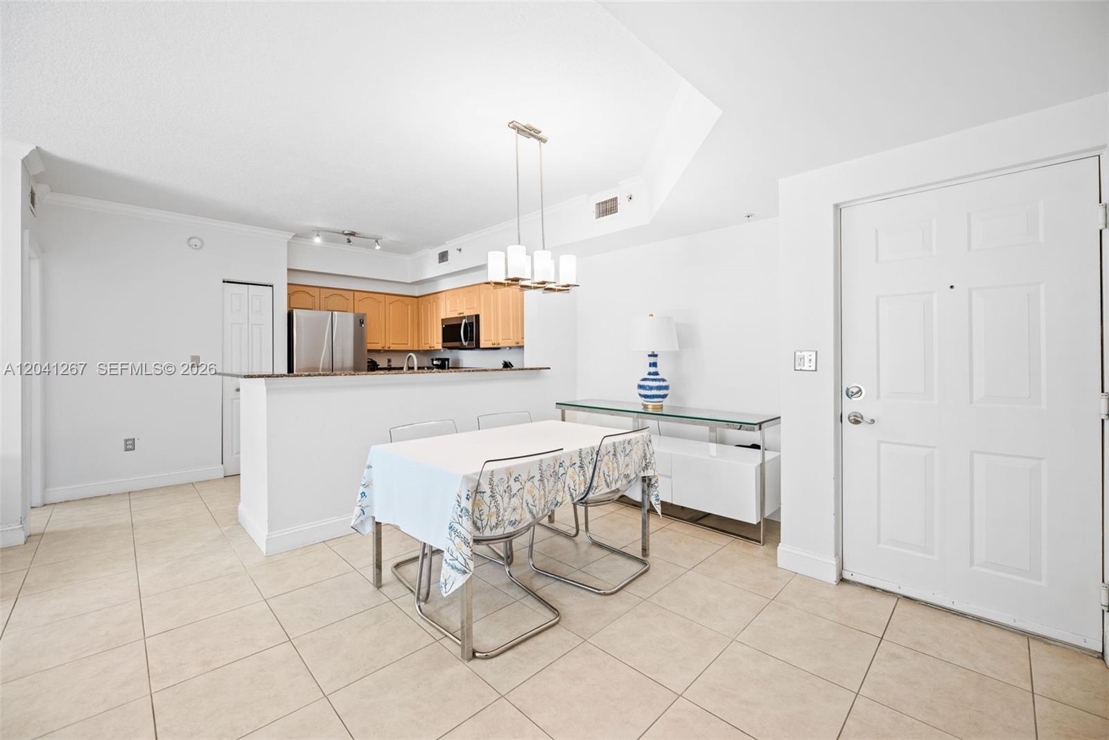 A dining area features a table with chairs, a console table, and an open kitchen — 6861 SW 44th St # 202, Miami FL 33155, MIAMI, FL