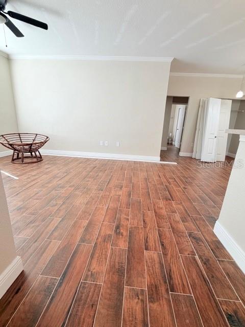 An empty room features wood-look tile flooring, light-colored walls, and a round wicker chair — 9108 LAKE CHASE ISLAND WAY UNIT 9108, TAMPA, FL