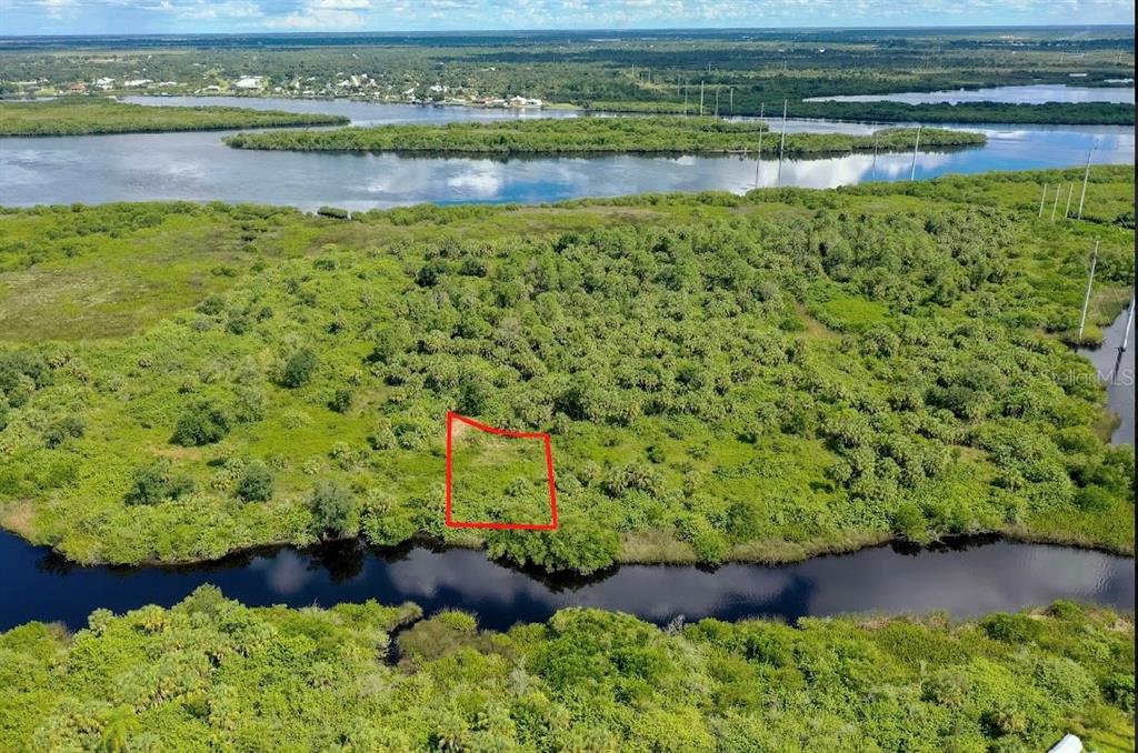An aerial view shows a rectangular plot of land outlined in red near a waterway — 1591 VERANDA TERRACE, PUNTA GORDA, FL
