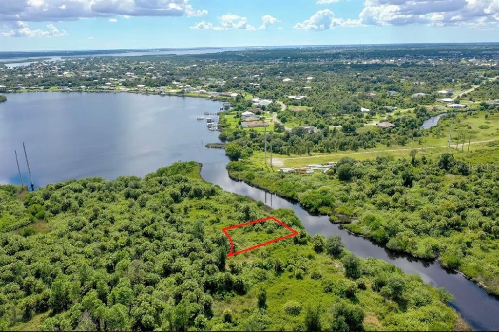 An aerial view shows a rectangular plot of land outlined in red near a waterway — 1591 VERANDA TERRACE, PUNTA GORDA, FL