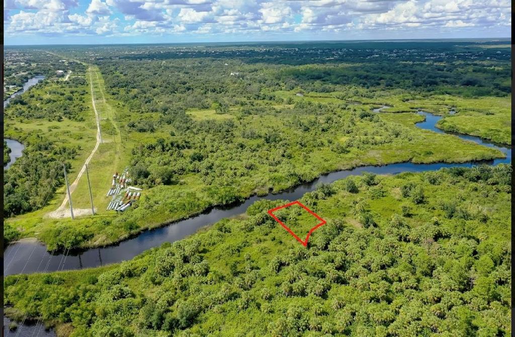 An aerial view shows a rectangular plot of land outlined in red near a waterway — 1591 VERANDA TERRACE, PUNTA GORDA, FL