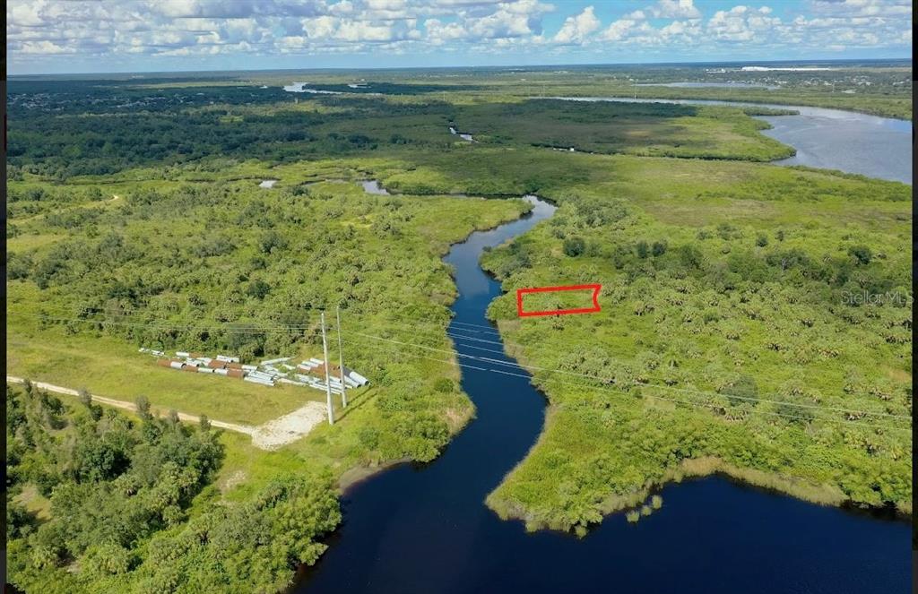 An aerial view shows a rectangular plot of land outlined in red near a river — 1591 VERANDA TERRACE, PUNTA GORDA, FL