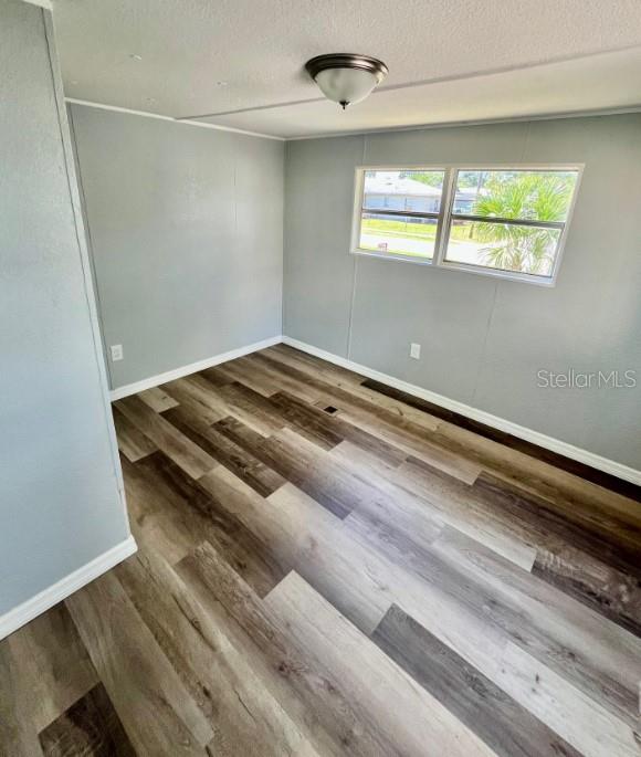 An empty room with light gray walls, wood-look vinyl flooring, and a single window — 225 ADAMS STREET UNIT A, AUBURNDALE, FL