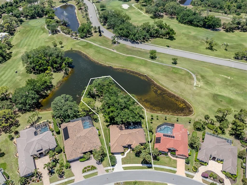 An aerial view shows a house with a white property boundary line near a pond — 2120 MUSKOGEE TRAIL, NOKOMIS, FL