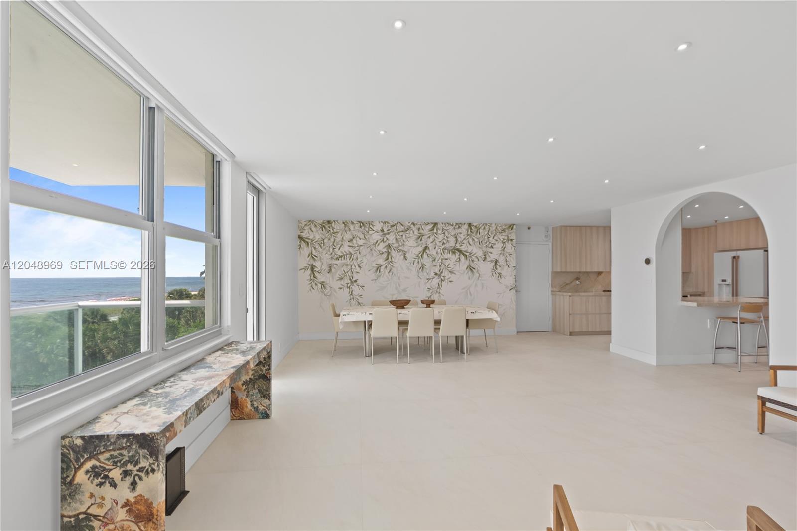 A dining area with a floral mural wall, marble console, and ocean view windows — 9511 Collins Ave # 403, Surfside FL 33154, SURFSIDE, FL