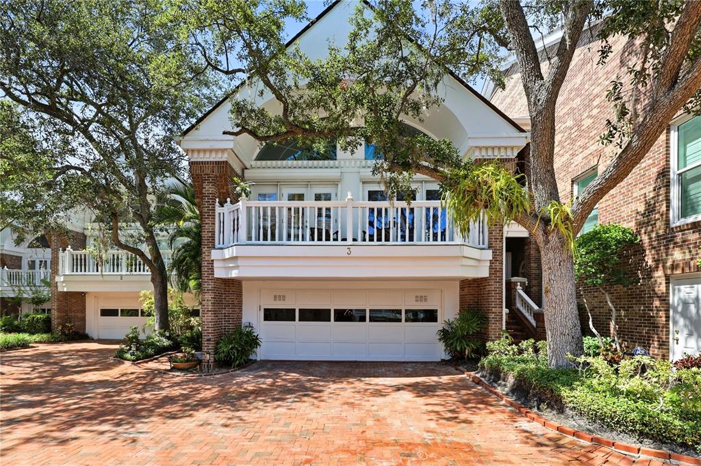 A brick-paved driveway leads to a two-story brick townhouse with a white garage door — 5210 INTERBAY BOULEVARD UNIT 3, TAMPA, FL