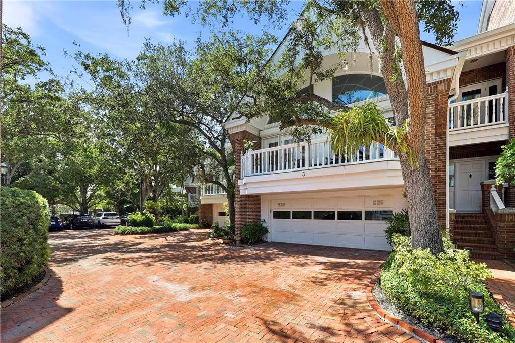 A multi-story brick townhouse with a white garage door and a second-story balcony — 5210 INTERBAY BOULEVARD UNIT 3, TAMPA, FL