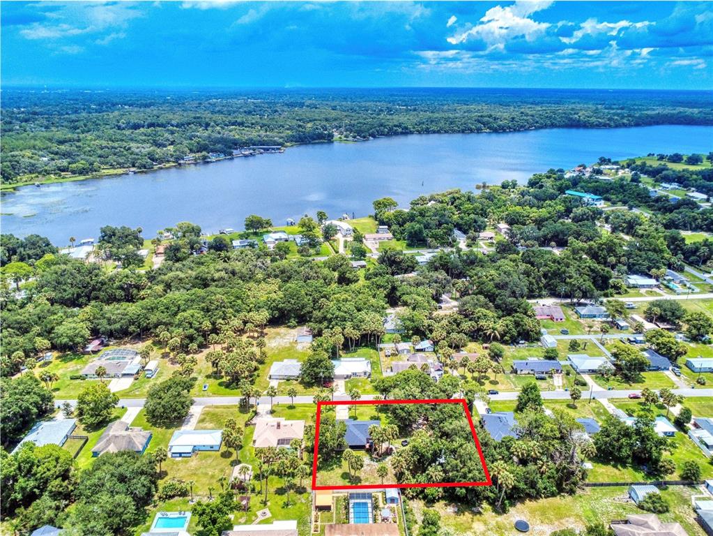 An aerial view shows a residential property outlined in red near a large lake — 1624 CENTER STREET, DELAND, FL