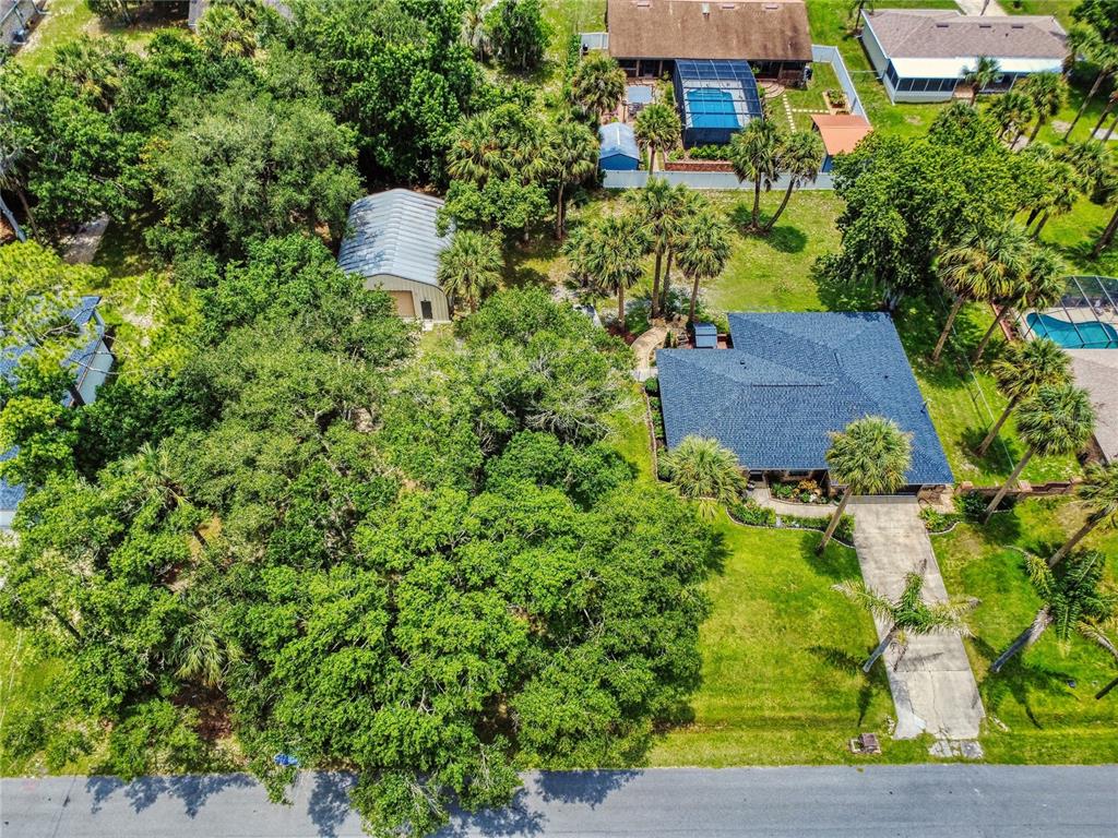An aerial view shows a house with a blue roof, a detached garage, and trees — 1624 CENTER STREET, DELAND, FL