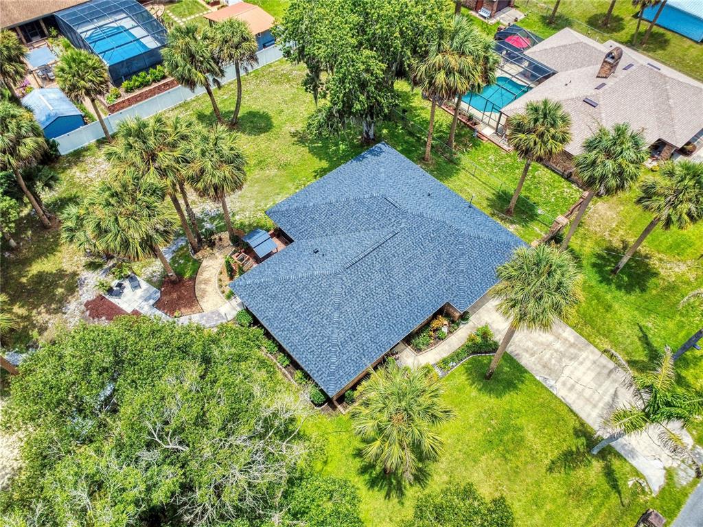 An aerial view shows a house with a dark shingled roof surrounded by palm trees — 1624 CENTER STREET, DELAND, FL