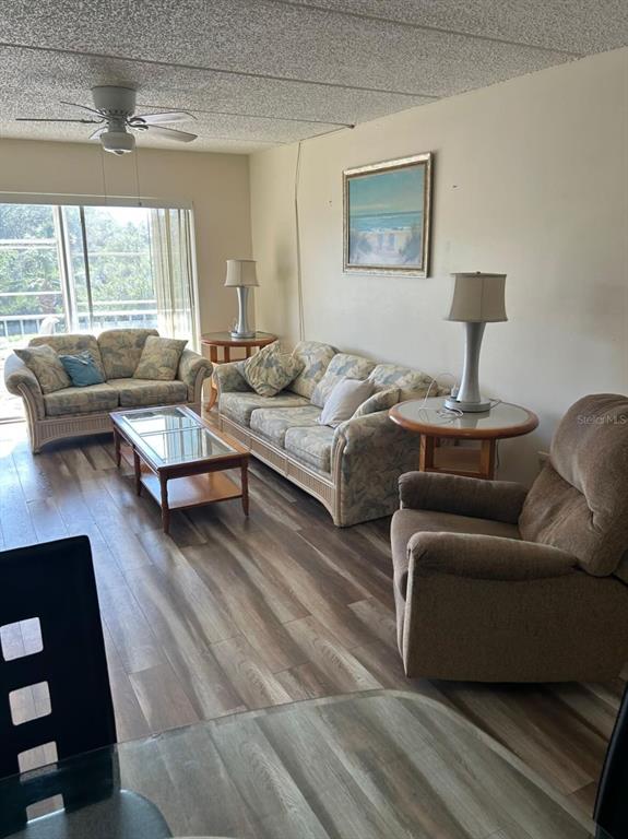 A living room features a sofa, loveseat, recliner, coffee table, and wood-look flooring — 12760 INDIAN ROCKS ROAD UNIT 1048, LARGO, FL