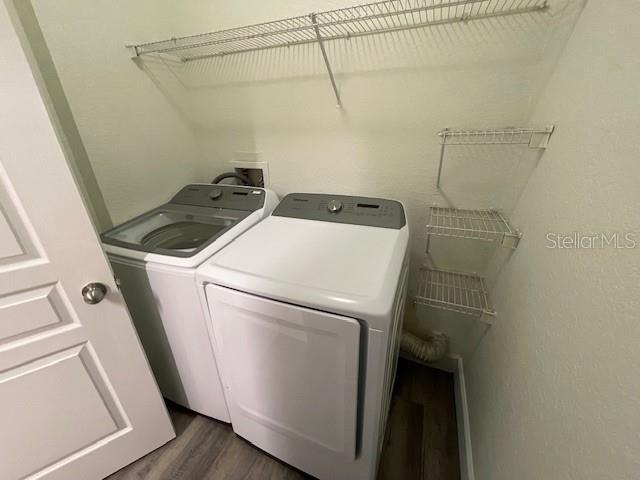 A laundry room features a side-by-side washer and dryer with wire shelving above — 5125 PALM SPRINGS BOULEVARD UNIT 11203, TAMPA, FL