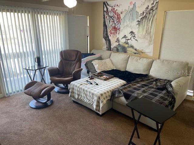 A living room features a sectional sofa, a recliner with ottoman, and a wall tapestry — 48 CLUB HOUSE DRIVE UNIT 204, PALM COAST, FL